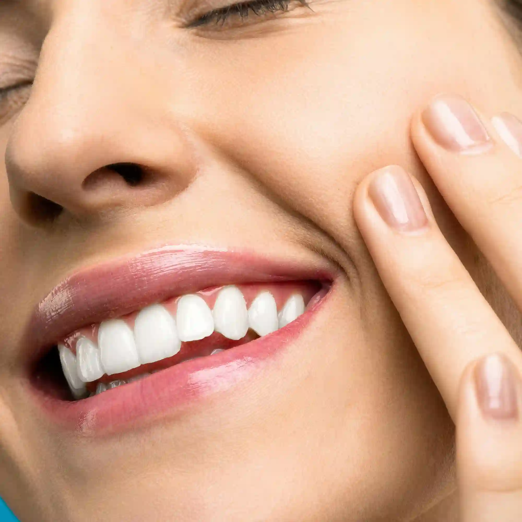 Primo piano ravvicinato del viso di una donna sorridente che mostra una dentatura bianca e perfettamente allineata mentre si tocca la guancia, rappresentando il risultato di trattamenti di igiene orale e ortodonzia offerto da ortodonzia semeraro.